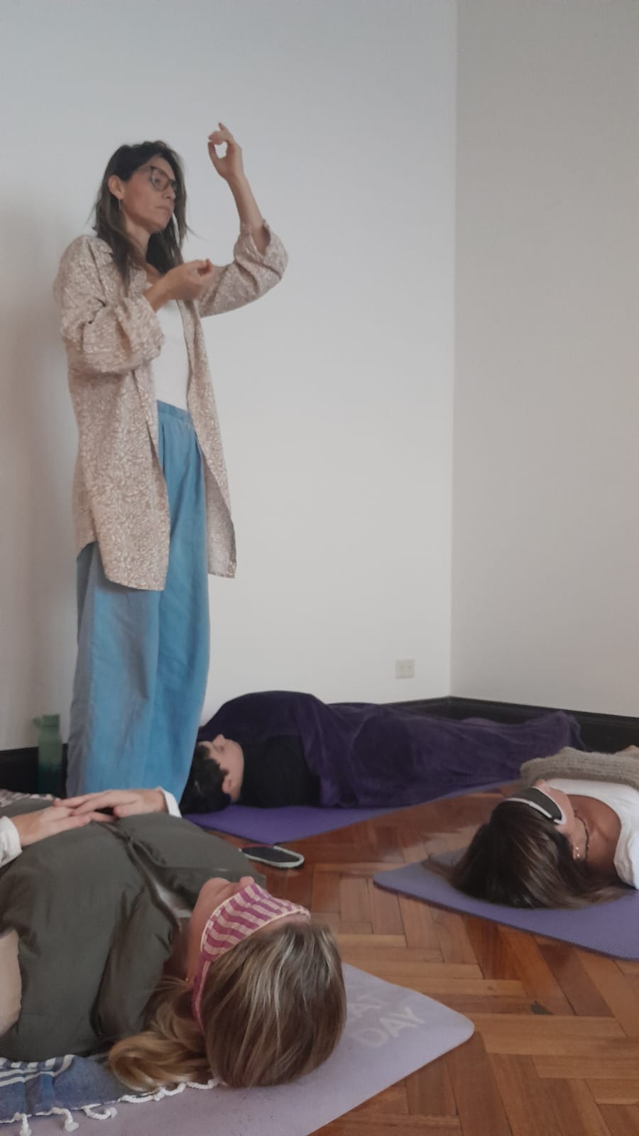 Jime guiando una respiración mientras el grupo descansa en colchonetas